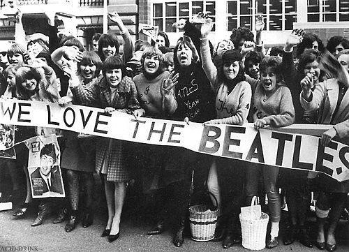 Fãs segurando um cartaz para os Beatles.